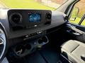 Interior view of a 2023 Mercedes-Benz Sprinter showing the dashboard with a touchscreen display and black leather seating