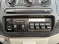 Control panel of a 2008 Ford F-550 featuring various switches and knobs for lights and air conditioning