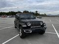 A black 2019 Jeep Wrangler positioned in a parking lot showcasing its angular body and distinctive front grille with round headlights