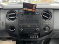 The interior dashboard of a 2015 Ford F-550 featuring control knobs air vents and a digital display with various buttons