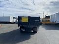 A 2003 Ford F-450 SD truck with a black dump bed and a yellow sign on it indicating it is for sale