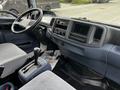 Interior view of a 2006 Hino 268 featuring a driver's seat steering wheel dashboard and gear shift with gray fabric upholstery