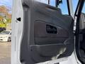 A side door panel of a 2011 International WorkStar featuring a textured dark handle and a smooth black surface with a fabric insert