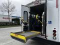 A 2016 Ford Econoline with a wheelchair lift extended at the back doors designed for accessibility