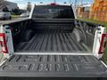 An empty truck bed of a 2021 Ford F-150 with a textured surface and the Ford logo embossed on the interior panel