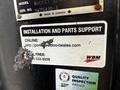 A label on a Caterpillar 306 machine displaying installation and parts support information with a website and a toll-free phone number