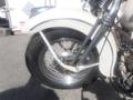 A close-up view of the front wheel and fender of a 1947 Harley-Davidson WL motorcycle showing the chrome spokes and white tire