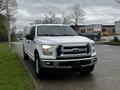 A white 2017 Ford F-150 parked with a front view showcasing its chrome grille headlights and body details