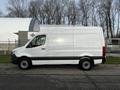 A white 2022 Mercedes-Benz Sprinter van is parked, showcasing its simple and functional design with a tall cargo area and sleek profile