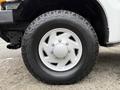 A close-up of a white wheel and tire on a 2001 Ford F-350 featuring a multi-spoke alloy rim and rugged all-terrain tire design