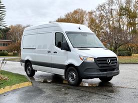 2023 Mercedes-Benz Sprinter van in white with a distinctive grille and large cargo space on the back