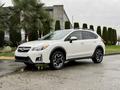 A white 2016 Subaru Crosstrek with black and silver alloy wheels parked on a wet surface
