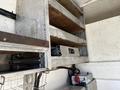 Shelves made of metal with wood panels inside a vehicle storage compartment with various tools and equipment visible
