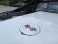 A 1972 Chevrolet Corvette emblem featuring a crossed flag design with a red flag and a checkerboard flag in a circular badge