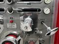 A metallic control panel from a 1991 Sutphen Deluge featuring dials levers and a shiny valve with a label indicating the Sutphen manufacturer