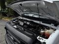 A 2017 Ford Econoline with its hood raised displaying the engine compartment and various mechanical components