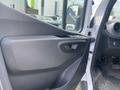 A cabin door panel of a 2024 Mercedes-Benz Sprinter featuring a black plastic handle and control buttons