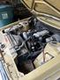 Engine compartment of a 1978 Volvo 244 showing various components including hoses wires and metal parts. The interior is dusty with visible wear from age