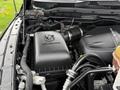 A 2018 RAM 1500 engine showing the black air intake box labeled RAM and the engine components including hoses and a fluid reservoir