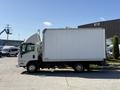 A 2013 Isuzu NPR box truck with a white cargo area and a driver's cab visible on one side