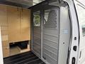 A 2013 Ford Econoline van interior featuring metal partitions and built-in wooden storage cabinets on one side