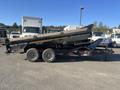 A 2024 Southland 18 Foot Dump Trailer with a black exterior and single axle design positioned for utility use