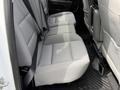 Interior view of a 2018 Chevrolet Silverado 1500 showing the back seat with grey fabric upholstery and seat belts