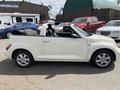 A 2005 Chrysler PT Cruiser convertible parked with its top down displaying a white exterior and silver wheels