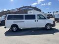 A white 2012 Chevrolet Express van with sliding side doors and black tinted windows parked on a paved surface
