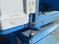 A close-up of a 1997 Genie S-65 4X4 with a blue exterior showing controls and electrical connections