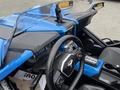 The interior of a 2020 Polaris Slingshot featuring a blue dashboard steering wheel and control buttons along with a digital display and gear shift