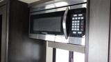 A Furrion microwave mounted in a 2021 Grand Design Recreational 311BHS with a sleek stainless steel finish and a digital control panel