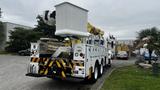 A 2006 International 7500 utility truck featuring a large boom lift and various compartments for tools and equipment