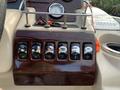 A control panel featuring multiple switches and a gauge for a 2013 Sylvan 13 Person boat