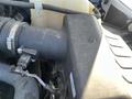 Close-up of a 2016 Ford F-250 SD engine component showing a black air intake housing with connected wiring and a partially visible coolant reservoir