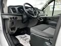 Interior of a 2023 Ford Transit showing the driver's seat dashboard and controls with a thank you mat on the floor