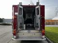 A red 1994 Freightliner FL80 with open rear doors showing the interior space designed for emergency services