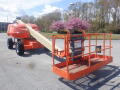 A 2008 JLG Boom Lift with a long extendable arm and a platform at the end red and orange in color with a safety railing around the working area