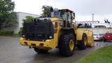 A 2019 Caterpillar 972M XE wheel loader with large tires and a front bucket, featuring a robust yellow body and a distinctive rear design