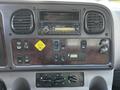 The dashboard of a 2016 Freightliner M2 106 featuring buttons and dials for controls along with a stereo unit at the top