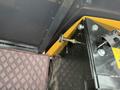 A close-up view of a control panel featuring a yellow knob and various metal components on the interior of a 2024 AGT Industrial Yellow H13R Mini Excavator