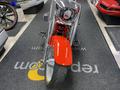 A 2024 Harley Davidson Fat Boy motorcycle in a prominent, frontal view showcasing its chrome details and distinctive red front fender