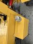 A close-up view of a yellow hydraulic tank with a silver cap on a 2024 AGT Industrial KRW23 Mini Loader