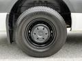 A black wheel with a silver hubcap featuring the Mercedes-Benz logo fitted on a 2023 Mercedes-Benz Sprinter van