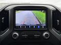 A digital rearview camera display showing a view of a road with guide lines for parking on a 2022 GMC Sierra 3500HD dashboard screen