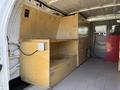 Interior of a 2011 Ford Econoline van featuring wooden storage units with drawers and a countertop space