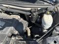 The image shows the engine compartment of a 2013 Chevrolet Express with various components including the air intake hose oil filter and coolant reservoir.