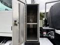 An open metallic storage compartment on a 2016 Peterbilt 348 truck showcasing its interior with no items inside