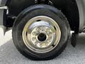 Close-up of a silver wheel and tire of a 2009 Ford F-550 featuring a shine finish with visible lug nuts and a Goodyear tread pattern