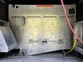 A 2016 Ford F-550 with a metallic storage compartment featuring various pipes and fittings along the inner walls and a yellow rope secured to one side